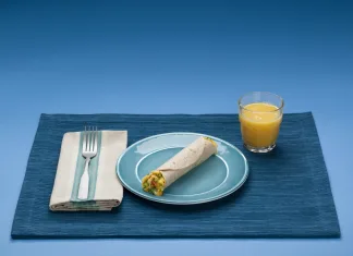Café da manhã proteico para emagrecer: 9 ideias práticas para mais saciedade Wrap de café da manhã com ovos, queijo e legumes em prato azul