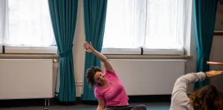 Alongamento matinal: rotina segura para mobilidade e disposição alongamento matinal em aula de yoga com pessoas vestidas