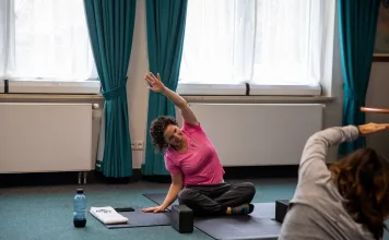 Alongamento matinal: rotina segura para mobilidade e disposição alongamento matinal em aula de yoga com pessoas vestidas